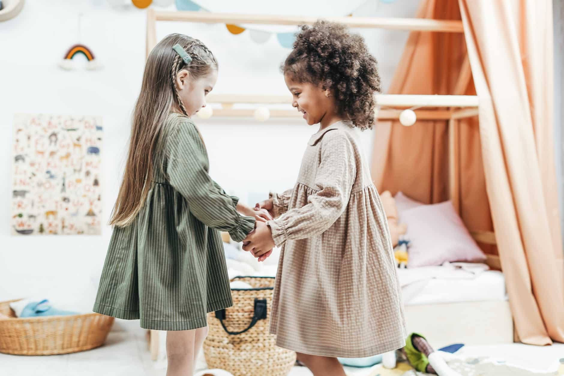 photo of girls wearing dress while holding hands