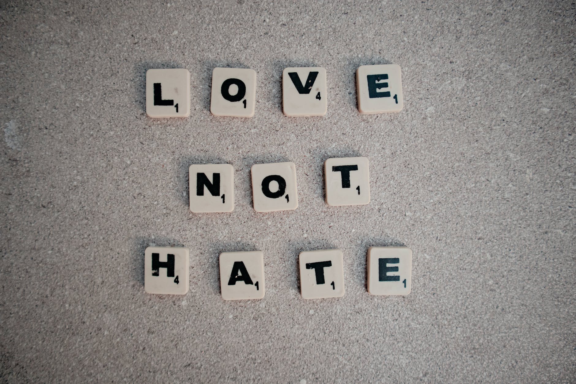 scrabble tiles spelling love not hate